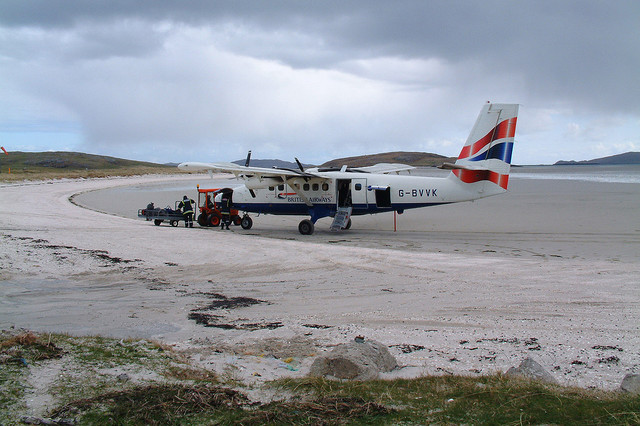 Plane landed at Barra Airport unloading baggage on beach