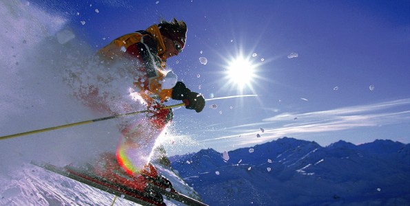 Skier jumping on snowy slope on a sunny day