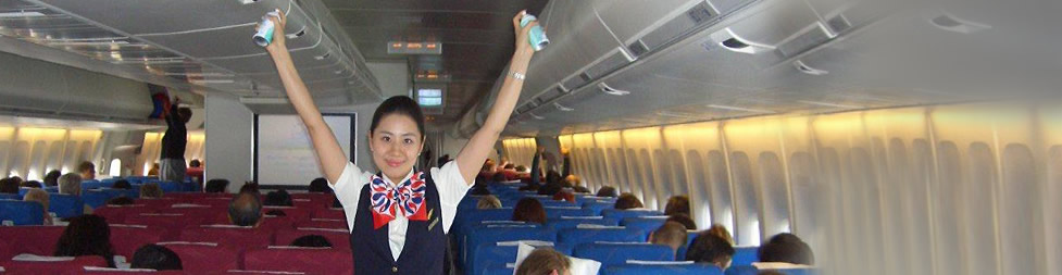 An Air Stewardess spraying disinfectant in the cabin of an airline before departure.