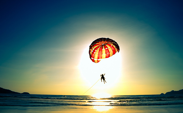 Paragliding during sunset on the beach in Thailand