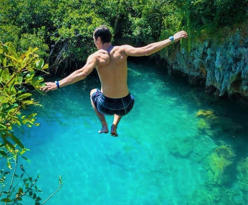 student jumping into lake