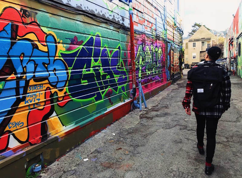 student looking at street art