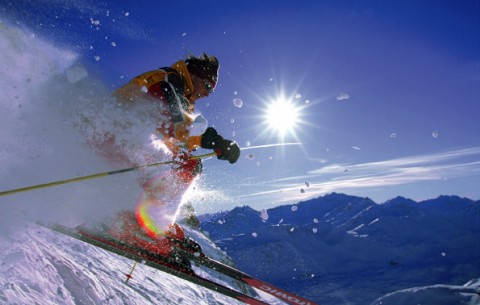 Skier jumping on snowy slope on a sunny day
