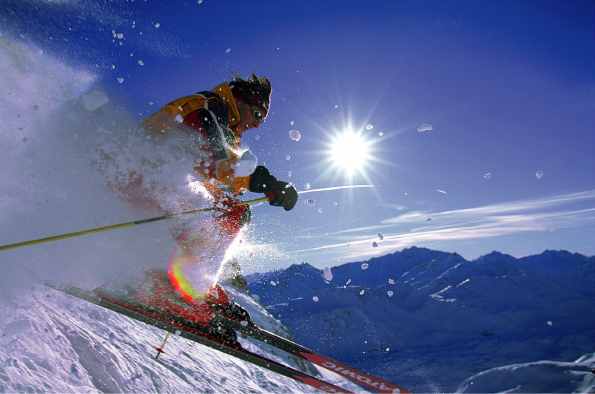 Skier jumping on snowy slope on a sunny day