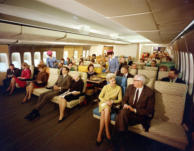 Passengers aboard a Boeing 747 enjoy the spacious economy class configuration.