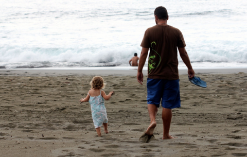 A Father and and his daughter head to the beach.