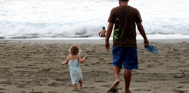 A Father and and his daughter head to the beach.