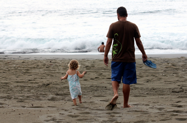A Father and and his daughter head to the beach.