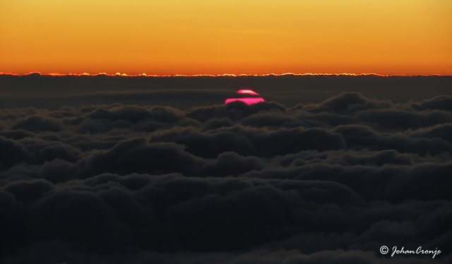 The sun breaking through a layer of cloud. Early morning somewhere over Botswana.