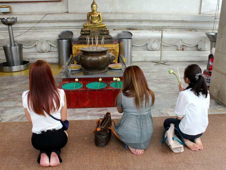 Girls making an offering in a temple.
