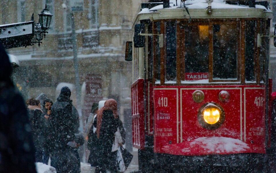 A red tram moving through snowy streets in Istanbul, a familiar winter scene for travellers exploring the city on a Turkish visa.
