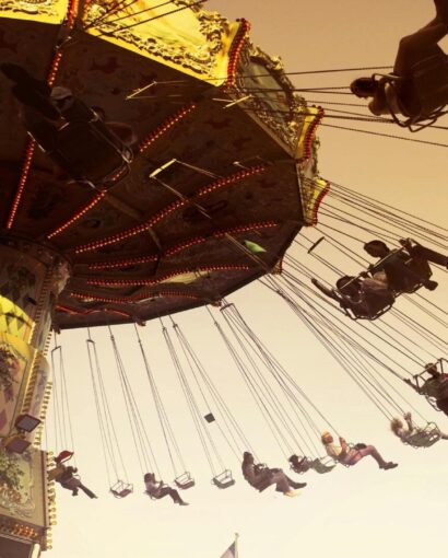 People enjoying a swing ride at a festive amusement park in Johannesburg during December 2025, capturing the fun and adrenaline of things to do in Johannesburg during the summer holiday season.