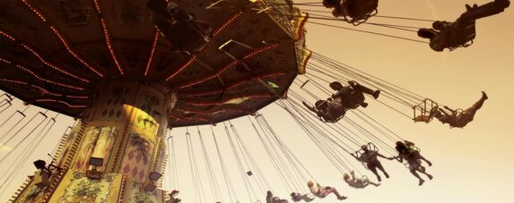 People enjoying a swing ride at a festive amusement park in Johannesburg during December 2025, capturing the fun and adrenaline of things to do in Johannesburg during the summer holiday season.