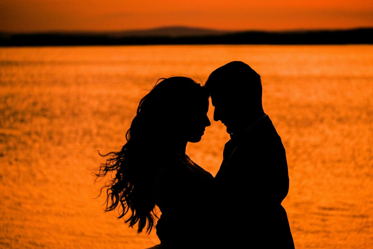 Couple embracing in the ocean during a sunset. Here are the top 7 romantic Valentine's getaway in South Africa 2025.