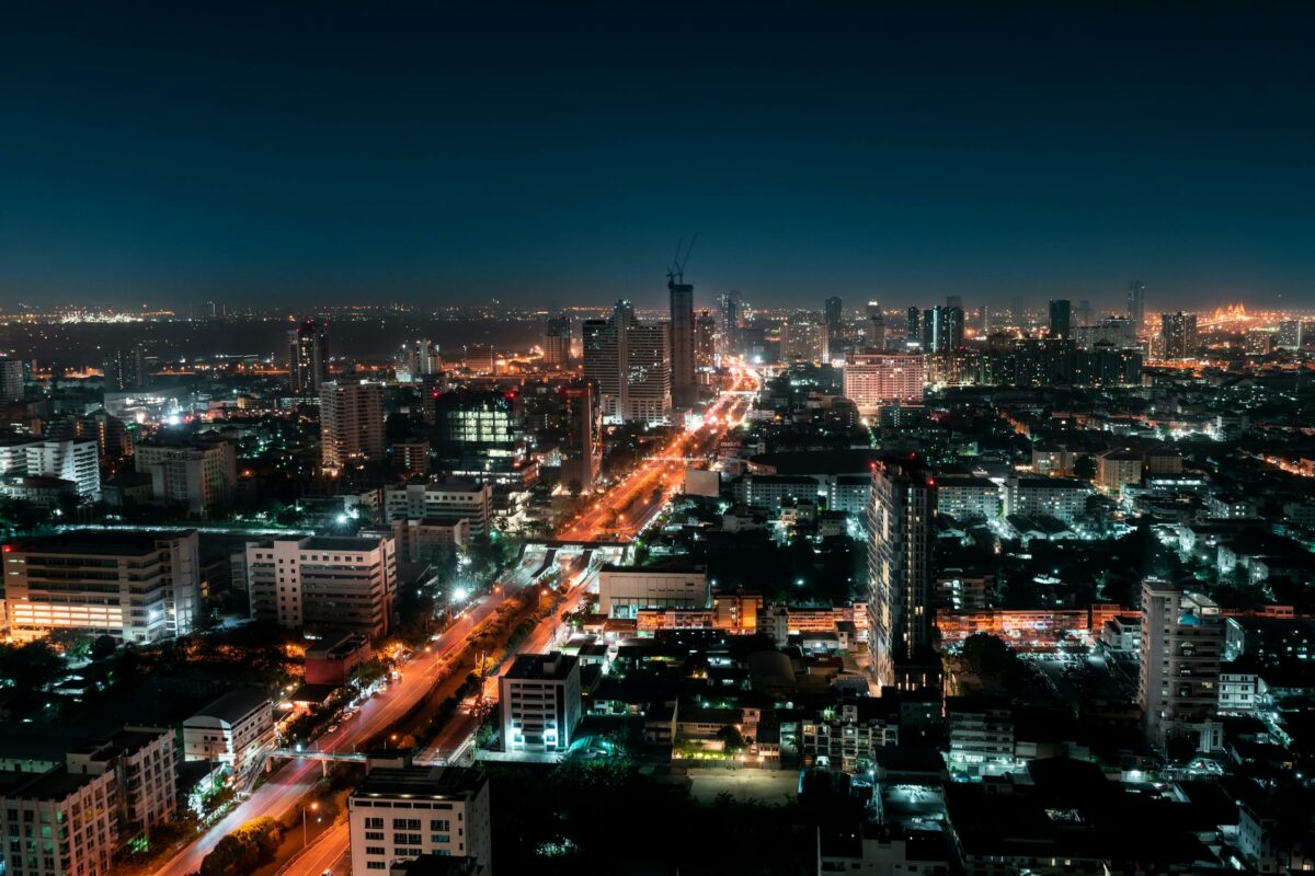Aerial view of the city of Bangkok at night. Brightly lit skyscrapers and the buzzing atmosphere Bangkok is known for.