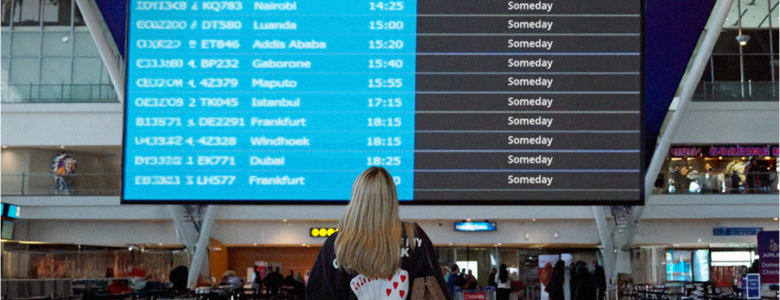 Lady looking at the flight boards at the airport wondering why flights are so expensive