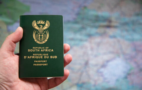Close-up of a hand holding a South African passport. Concept for how to apply for a South African passport, step by step guide