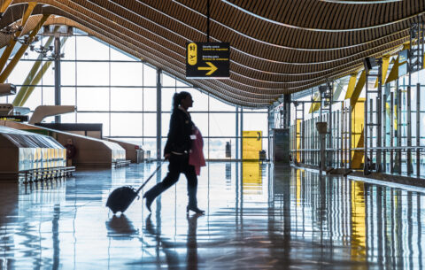 Dubai airport terminal with a moving silhouette of a woman and sunray.