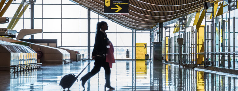 Dubai airport terminal with a moving silhouette of a woman and sunray.
