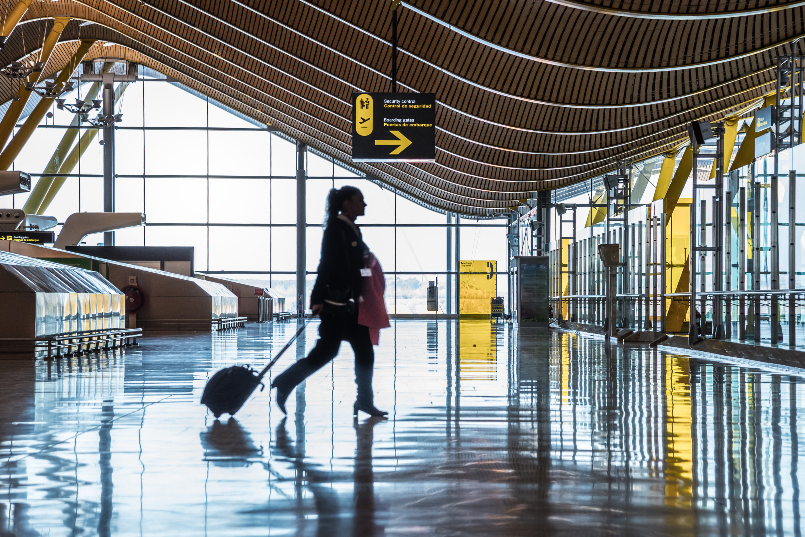 Dubai airport terminal with a moving silhouette of a woman and sunray.