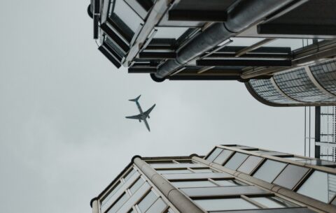 Airplane flying in between two buildings