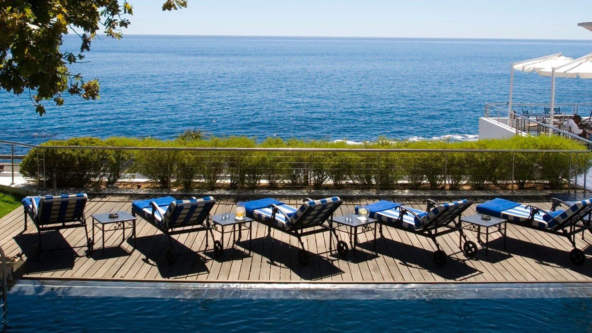 Pool chairs overlooking the crystal blue ocean from the luxury 12 Apostles Hotel in Cape Town, one of the affordable places to visit during Easter 2025