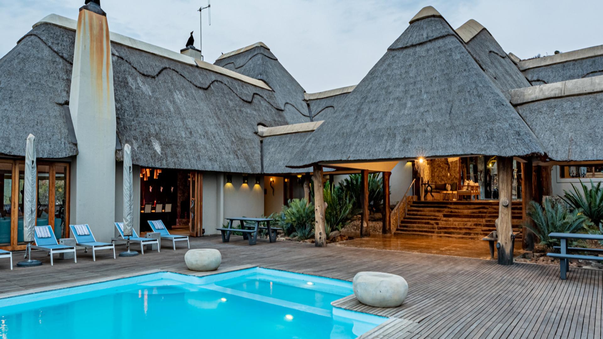 Thatched roof resort with a refreshing pool of blue water at Lion's Valley resort. This is one of the cheap easter getaways to try in 2025.