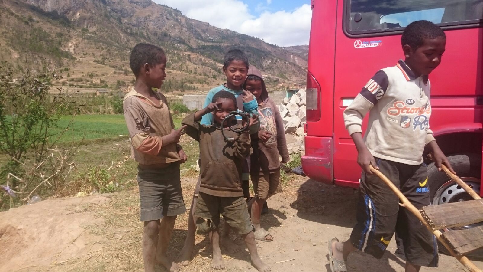 Kids playing, taxi brousse in the background Madagascar Mark Visser