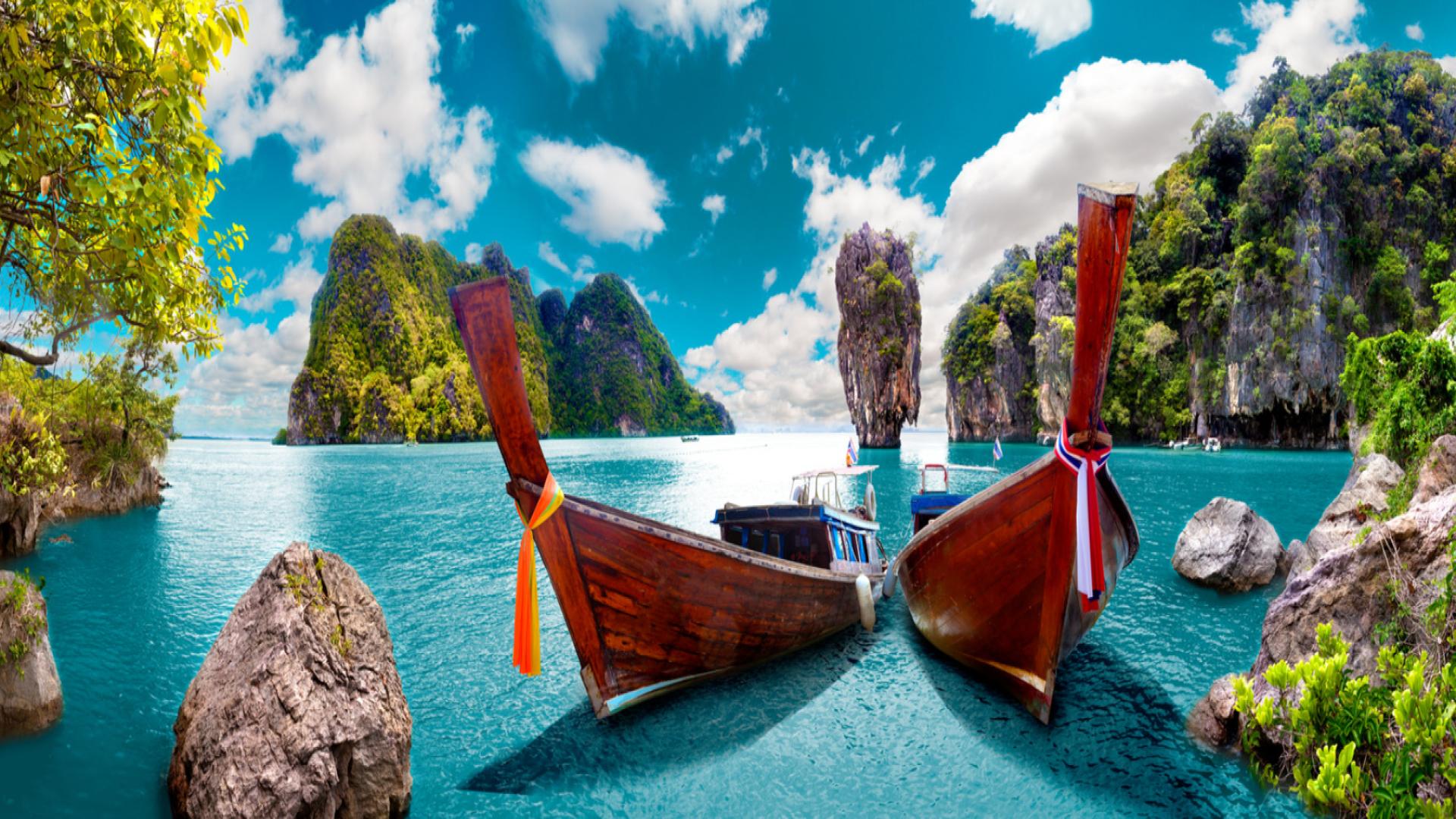 Traditional long-tail boats on turquoise waters surrounded by limestone cliffs and lush greenery under a vibrant blue sky in Phuket, Thailand. Top 5 cheap Rand-frienldy travel deals for Black Friday 2025