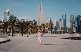 Woman standing in front of the Doha Skyline. Travel to Qatar