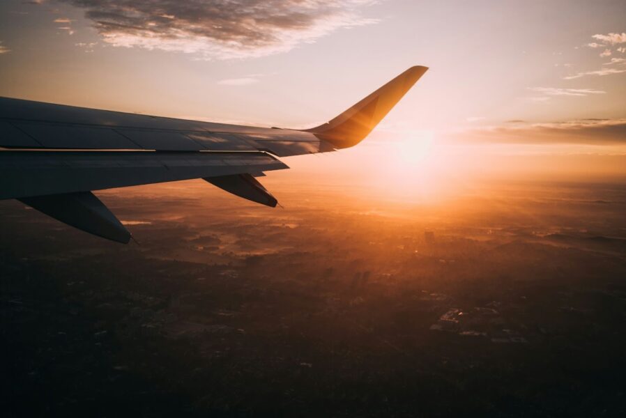 Plane wing flying during a sunset. This is an image for an explainer on ow to book multi-city flight bookings on Travelstart