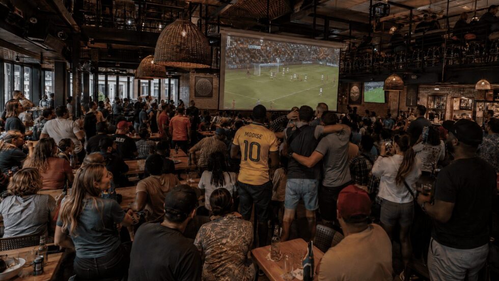 A crowd gathered in a bar to watch the 2026 FIFA World Cup in South Africa.